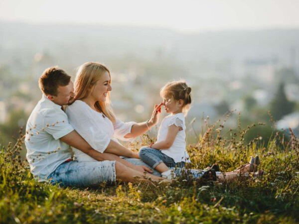parents sitting on grass with child