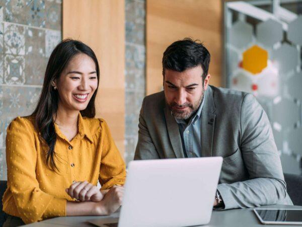man and woman looking at laptop screen