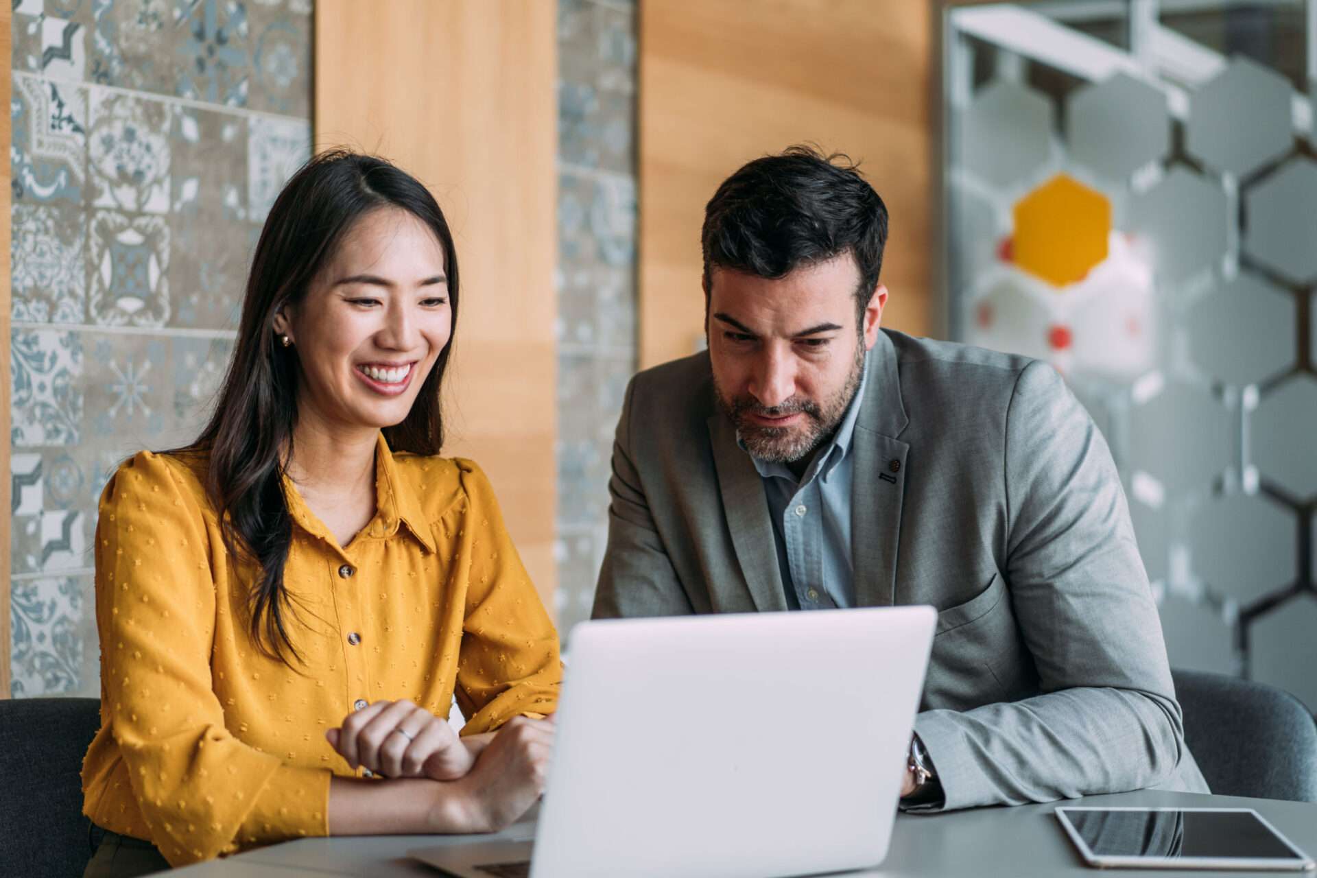 man and woman looking at laptop screen