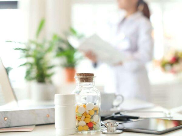 pill bottles on table with pharmacist in background