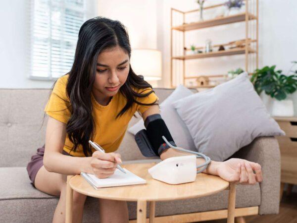 Young person taking blood pressure at home