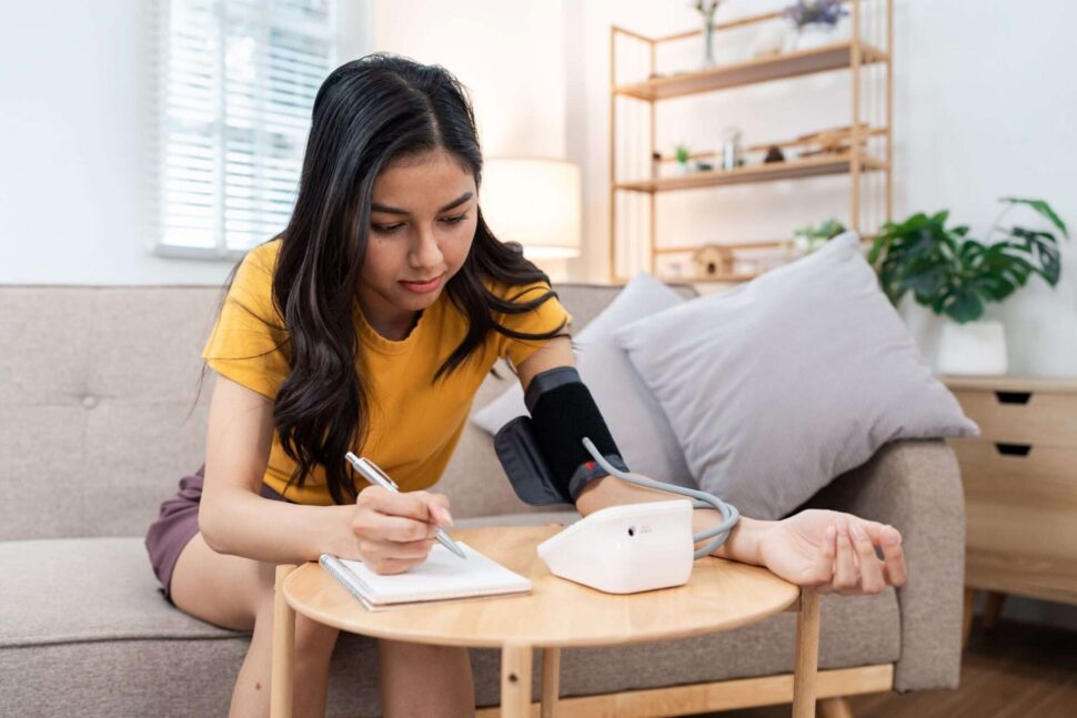 Young person taking blood pressure at home