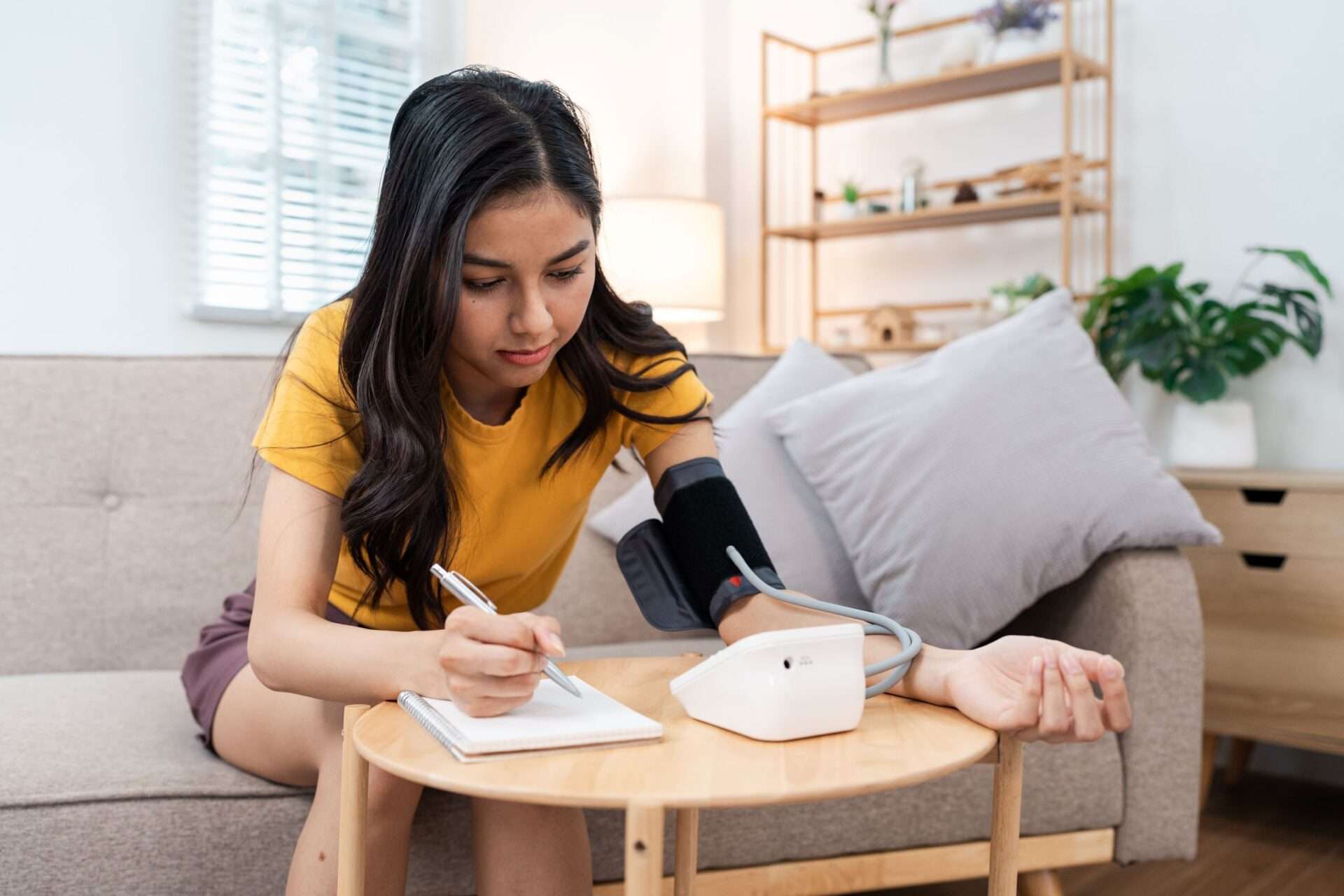 Young person taking blood pressure at home