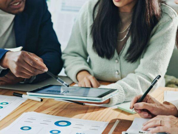 Business colleagues holding a tablet looking at reports