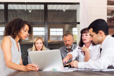 Group of businesspeople around a laptop