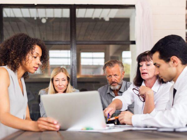 Group of businesspeople around a laptop