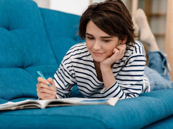 Woman doing homework on couch