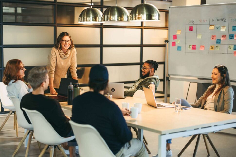 Colleagues at work around a white board having a brainstorm session
