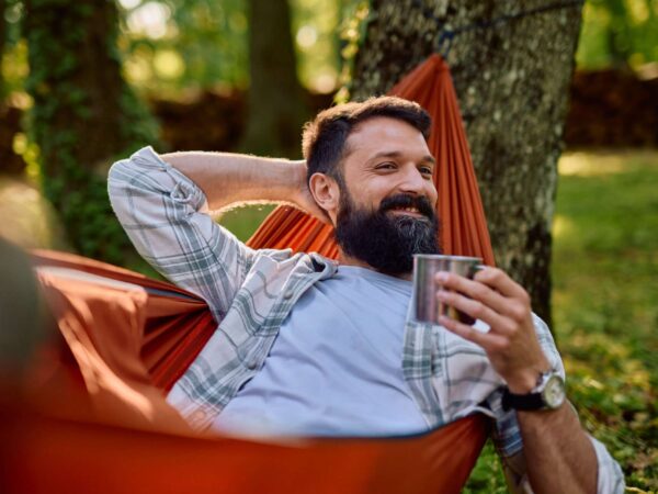 Home Man relaxing in hammock with coffee