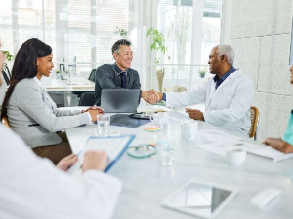 Home Doctors shaking hands at hospital meeting